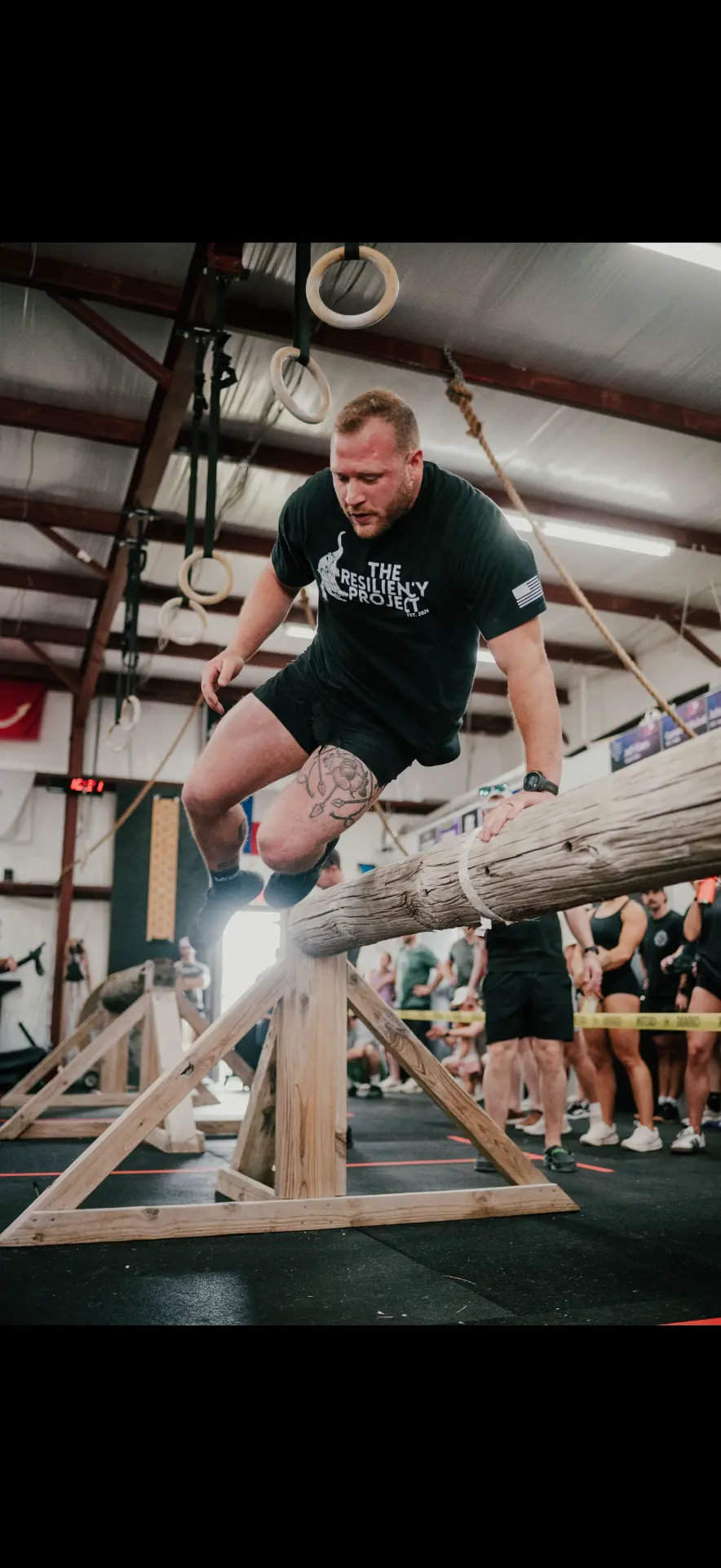 Athlete clearing a log obstacle during a Resiliency Project workout